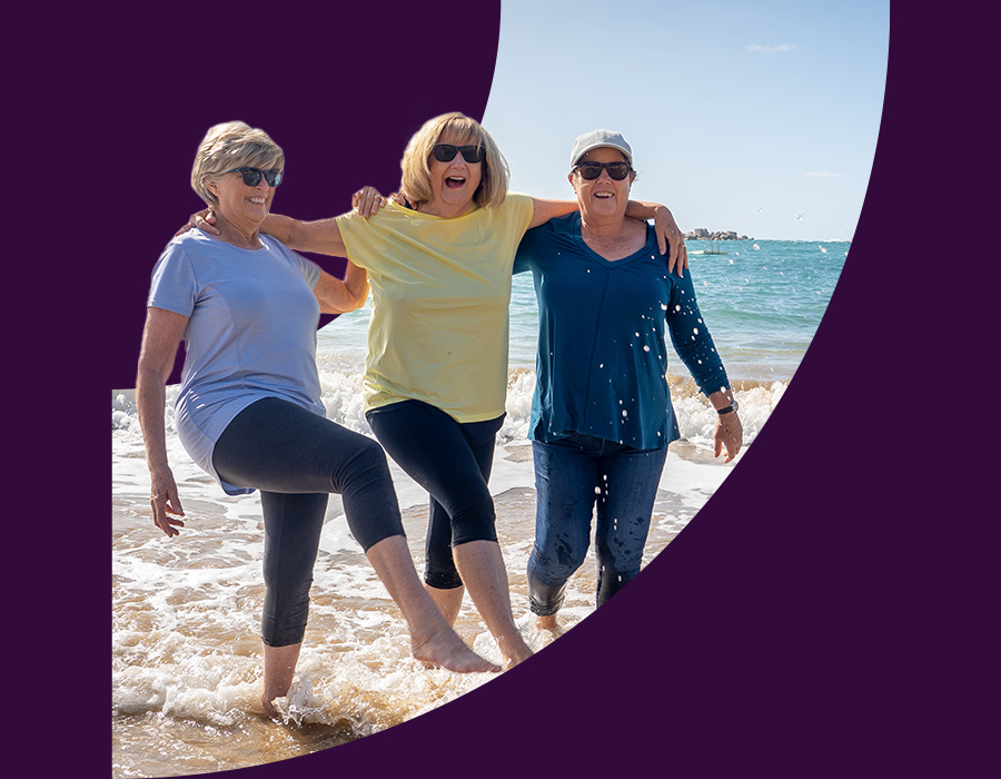Women frolicking in the shallow waves at the beach