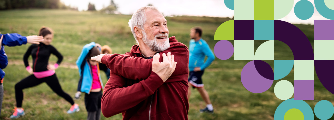 A number of adults stretching outdoors