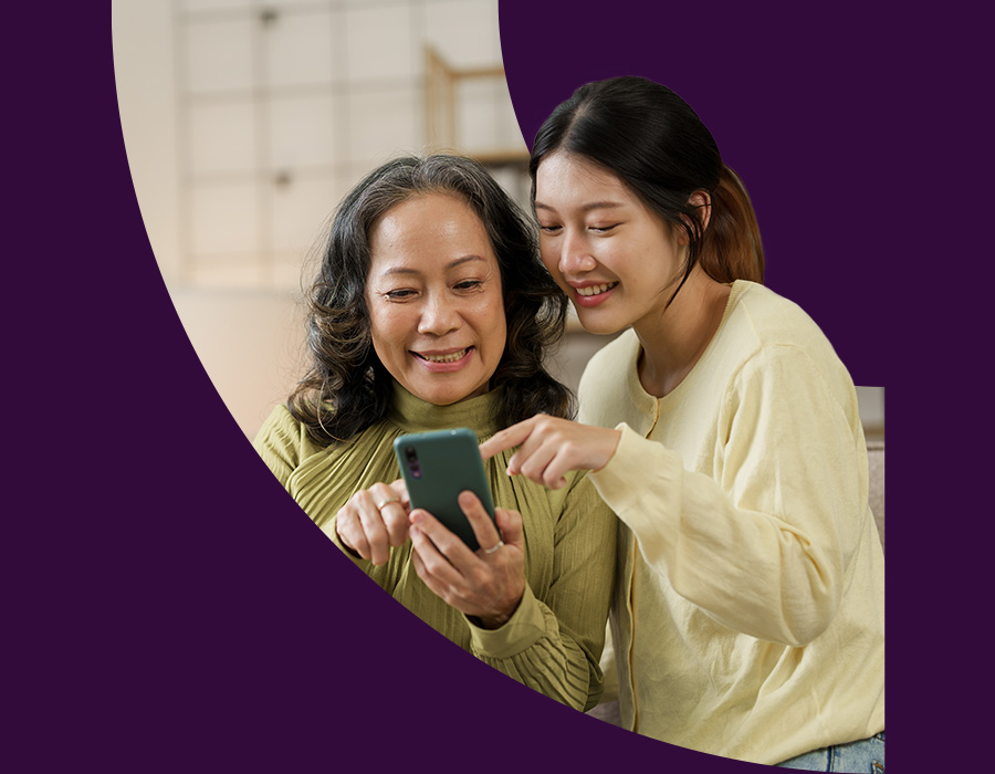 Asian mother and daughter looking at phone screen