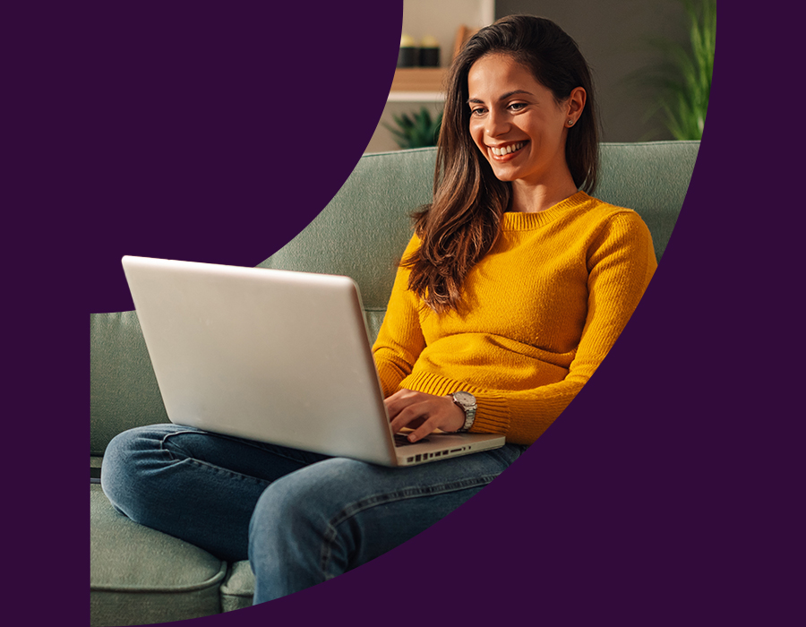 Woman sitting on her sofa with a laptop on her lap