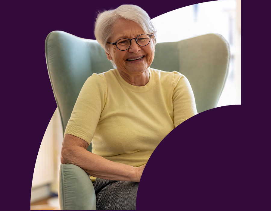 Old woman sitting in an armchair at home